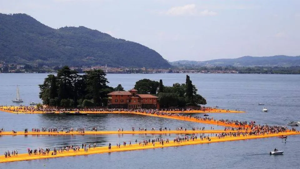 People walk on the monumental installation entitled ‘The Floating Piers’ created by artist Christo Vladimirov Javacheff on Iseo Lake, in northern Italy, on June 18, 2016. 
Some 200,000 floating cubes create a 3-kilometers runway connec
