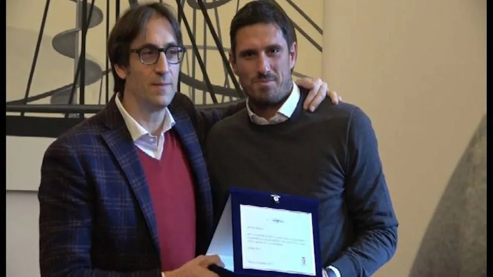 Alex Righetti e l’Assessore Brasini nel momento della consegna della targa