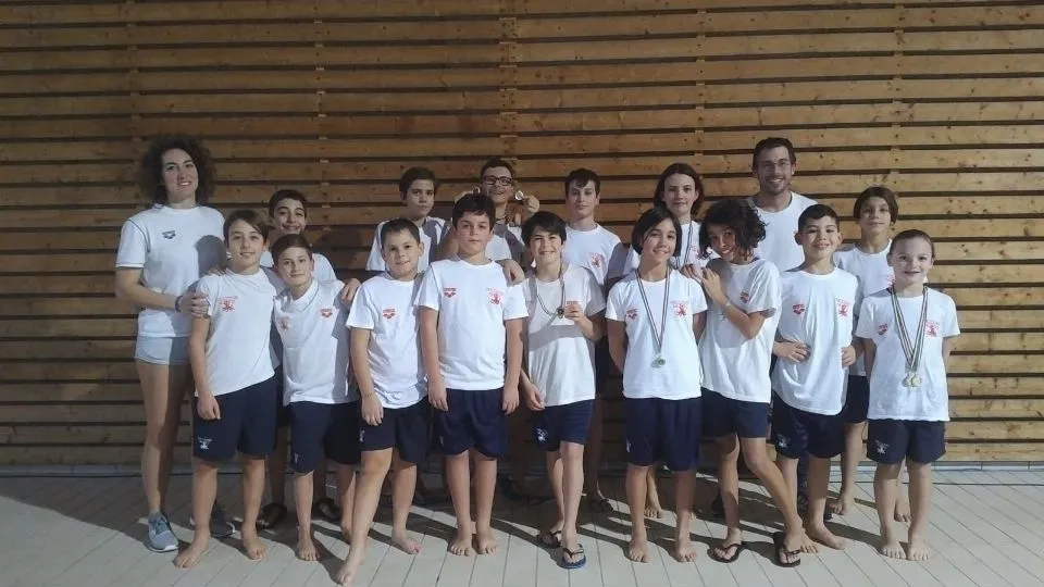 Il gruppo Esordienti del Nuoto Riccione con i tecnici Yari Caveduri ed Elena Corti