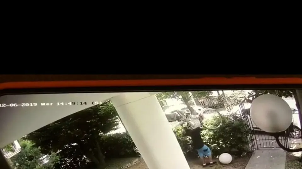 Il ladro mentre solleva la bici e la passa al complice
