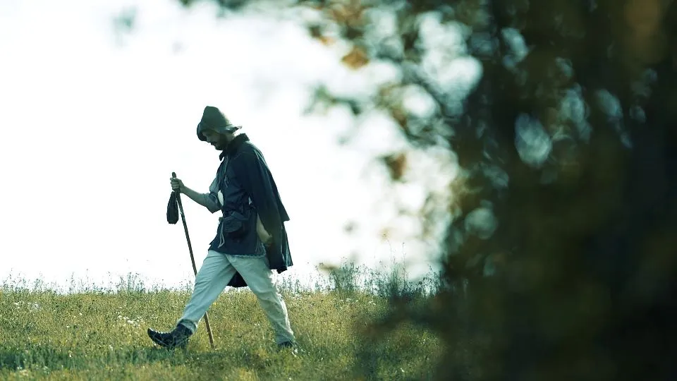 Un frame del documentario, con un figurante vestito alla maniera dei pellegrini antichi