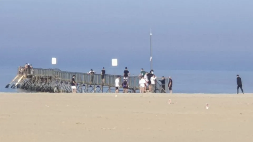 Ragazzini oggi pomeriggio su un pontile chiuso a Marebello