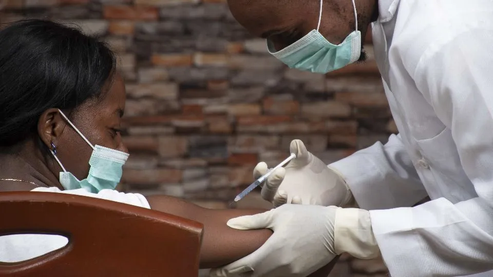 african doctor injecting an african woman with a vaccine for covid 19

