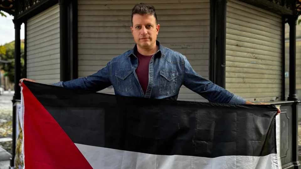 Filippo Sacchetti con la bandiera palestinese davanti al 