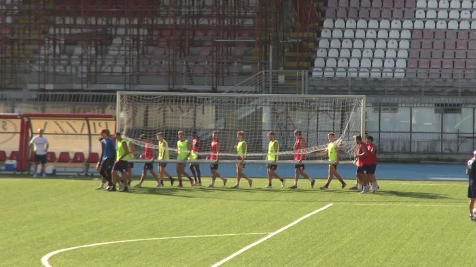 I calciatori del Rimini mentre trasportano una porta a metà campo