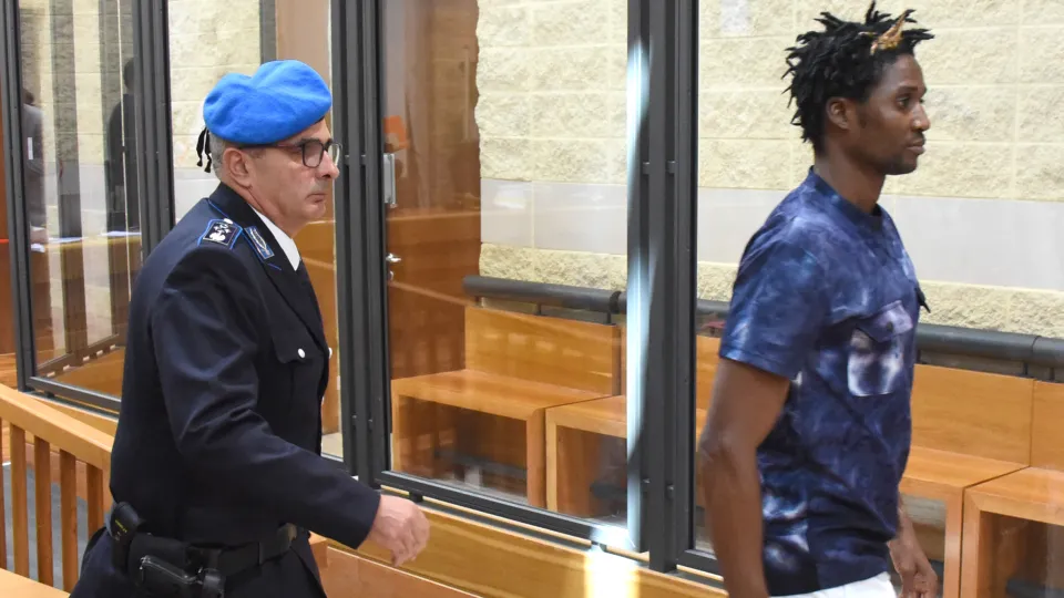 Louis Dassilva seguito da un agente della Penitenziaria in aula (foto Migliorini)