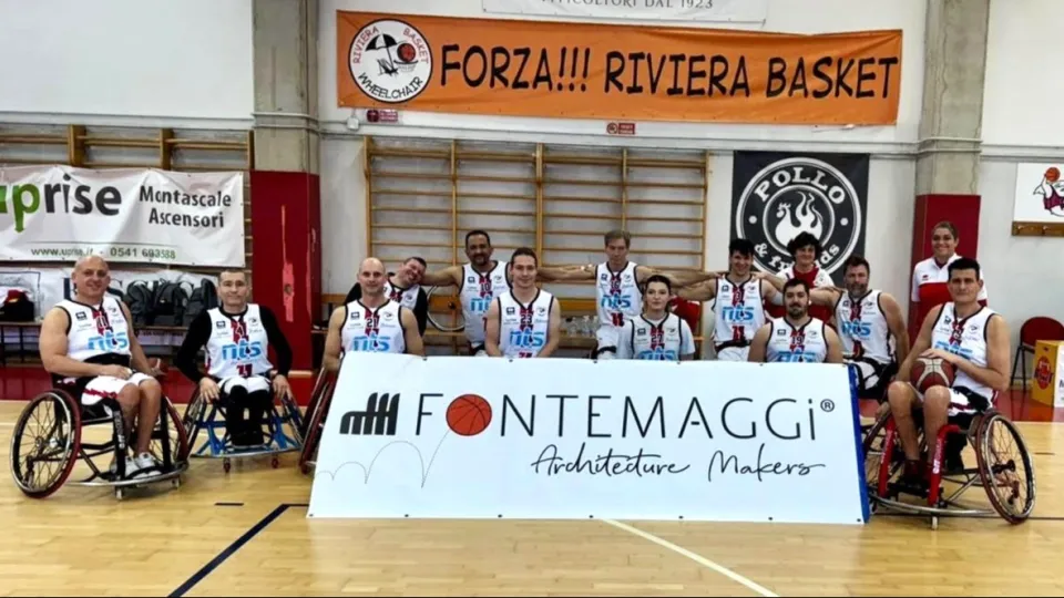 La squadra di Riviera Basket Rimini con lo striscione di Fontemaggi