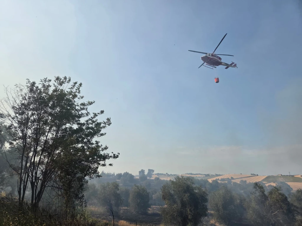 L'elicottero del 115 impegnato a spegnere l'incendio a Saludecio (Adriapress)